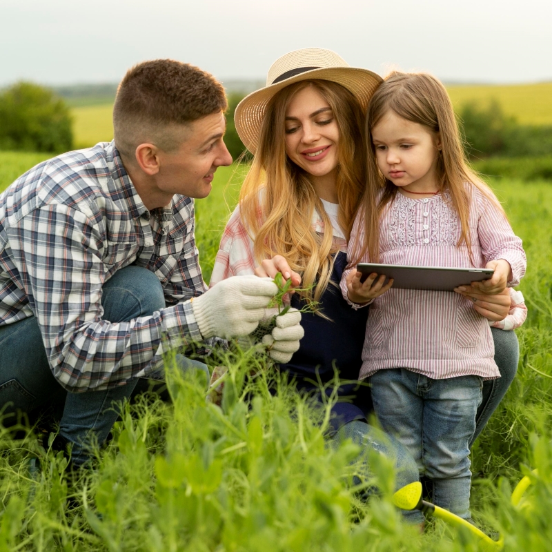Família em ângulo alto na fazenda com tablet